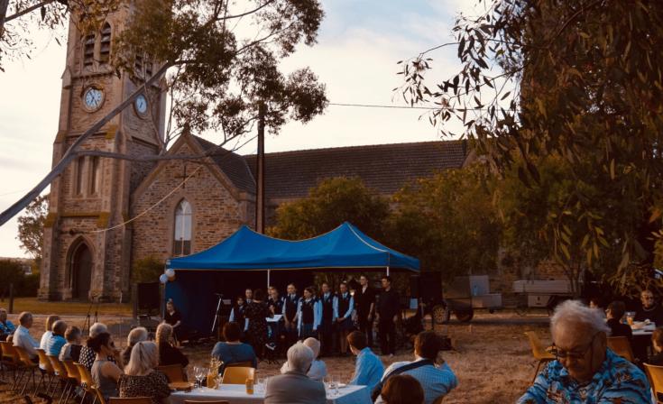 Eastern Fleurieu School vocal ensemble sing under the gum trees beside St Andrews Strathalbyn Uniting Church at a community barbecue to celebrate the church's 175th Anniversary.